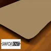 A close-up view of a tan fitted sheet on a bed, with a wooden floor visible below and a dresser in the background. A logo is present in the bottom left corner. Produktbild-Vorschau