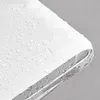 A close-up view of a white surface with water droplets and a silver metallic edge. Produktbild-Vorschau