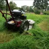 A rotary mower is cutting tall grass in a field. Produktbild-Vorschau