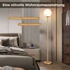 A modern bedroom with a floor lamp next to a nightstand and bed. Podgląd zdjęcia produktu