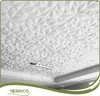 A white 3D geometric patterned ceiling panel with a modern design, illuminated by a light fixture hanging from it. Podgląd zdjęcia produktu