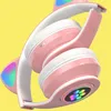 Close-up of pink and white headphones with LED lights. Voir les images du produit