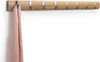A wooden coat rack with silver accents is mounted on a white wall. A pink scarf is hanging from one of the hooks. Produktbild-Vorschau