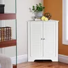 A white corner cabinet with louvered doors is shown in a room corner, next to a bookshelf and a window. Produktbild-Vorschau