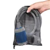 A hand holding a mesh bag containing a portable camping shower pump. Produktbild-Vorschau