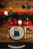 A festive Christmas table setting with candles, garland, and place settings. Produktbild-Vorschau