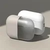 Two charging cases for wireless earbuds are placed on a light-colored surface with a gray wall in the background. Náhľad obrázku produktu