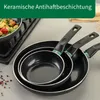 A set of three black frying pans with green accents, stacked on a countertop. Produktbild-Vorschau