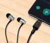 A pair of earphones connected to a smartphone via a USB-C DAC adapter, placed on a wooden surface. Produktbild-Vorschau