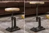 Two side-by-side images of an adjustable height side table with a wooden top and cast iron base, placed on a rug in front of a sofa. Produktbild-Vorschau