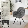 A grey velvet armchair with black metal legs is shown in a room setting, with a descriptive panel on the left. Produktbild-Vorschau
