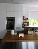 A modern kitchen with white cabinets, stainless steel appliances, and a wooden countertop. Podgląd zdjęcia produktu