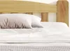 A close-up view of a bed with white bedding and a wooden headboard. Anteprima dell’immagine prodotto