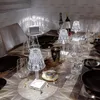 A table setting with decorative lamps, wine bottles, glasses, and a candle. Produktbild-Vorschau