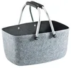 A gray felt basket with silver handles and black grips, shown against a white background. Náhled obrázku produktu