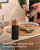 A person is using a pepper mill over a bowl of soup. Produktbild-Vorschau