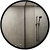 A round mirror with a black frame reflecting a modern bathroom with gray tiled walls and a shower head. Produktbild-Vorschau