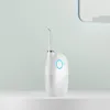 A white water flosser with a green accent ring sits on a white surface against a light green background. Náhled obrázku produktu