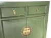 Close-up of a green wooden sideboard with gold hardware. Voir les images du produit