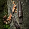 A knife and fire-starting materials are laid out on a rock and mossy surface. Produktbild-Vorschau