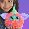 A young girl is holding a colorful Furby toy. Podgląd zdjęcia produktu