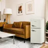 A retro-style mini-fridge next to a brown leather sofa in a living room. Produktbild-Vorschau