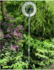 A thermometer in a garden surrounded by plants. Anteprima dell’immagine prodotto