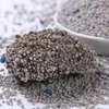 A close-up of clumping cat litter, with a pile of the litter in the foreground and more in a white bowl in the background. Anteprima dell’immagine prodotto