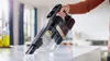 A hand holds a cordless vacuum cleaner over a countertop with some debris. Náhľad obrázku produktu