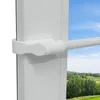 A close-up view of a white telescopic curtain rod attached to a window frame, with a blurred outdoor landscape visible through the window. Produktbild-Vorschau