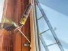 A person is using a foam dispenser to seal a window frame against a brick wall. Náhľad obrázku produktu
