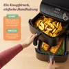 A person is using a dual-chamber air fryer, with one chamber filled with french fries and the other with salmon. Produktbild-Vorschau