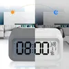 A digital alarm clock is shown in a split image, representing day and night, with a living room background. Voir les images du produit