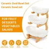 A three-tiered ceramic fruit bowl set with a bamboo stand, presented with marketing text and icons. Produktbild-Vorschau