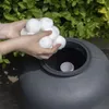 Hands holding white filter balls over a gray pool filter tank. Anteprima dell’immagine prodotto