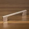 A single cabinet handle displayed on a wooden surface. Produktbild-Vorschau