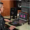 A person is using a MIDI controller connected to a laptop in a music studio setting. Anteprima dell’immagine prodotto