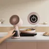 A hand presses a button on a pink mini range hood placed on a kitchen counter next to a portable induction cooktop with a pan of food. Náhľad obrázku produktu
