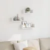 Three white U-shaped wall shelves are mounted on a white wall above a neutral-colored sofa. The shelves are decorated with vases, a plant, and framed pictures. Voir les images du produit