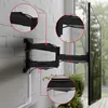 A black TV wall mount is attached to a white brick wall, with a TV attached to the mount. Close-up circles highlight specific parts of the mount. Anteprima dell’immagine prodotto