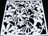 A white decorative screen with a floral and hummingbird pattern against a black background. Náhled obrázku produktu