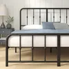 A close-up view of a black metal bed frame with a mattress and pillows. Produktbild-Vorschau