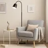 A modern living room scene with a floor lamp, an armchair, and a side table. Náhľad obrázku produktu