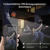 A security camera system is depicted, showing a camera mounted on a wall and a simulated view on a smartphone screen of a burglar. The scene is set at night, with the camera's light illuminating the area. Produktbild-Vorschau