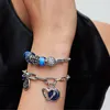 A close-up shot of a person's arm wearing two Pandora charm bracelets. Anteprima dell’immagine prodotto