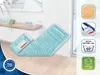 A blue mop head is laid out on a wooden floor in front of a white wall with furniture in the background. Icons and text are overlaid on the right side of the image. Produktbild-Vorschau