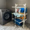 A laundry room with a washing machine and a drying rack filled with clothes. Voir les images du produit
