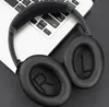 A pair of black over-ear headphones rests on a laptop keyboard. Produktbild-Vorschau