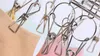 A close-up view of metal clothespins attached to a piece of fabric, likely a sock or underwear. Produktbild-Vorschau