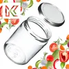 A clear glass jar with a silver lid, surrounded by fresh vegetables and herbs. Produktbild-Vorschau